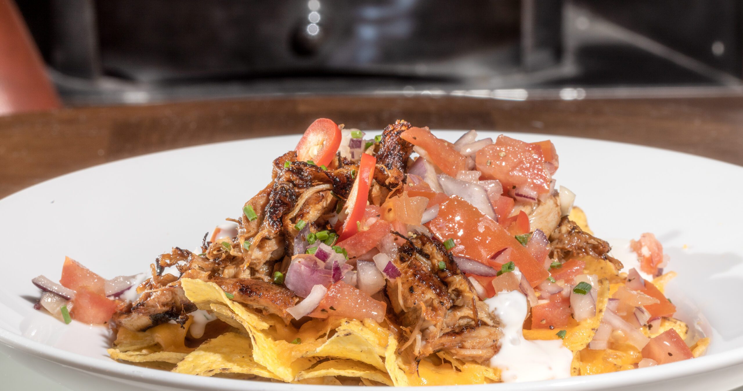 Loaded nachos with pulled pork, tomato salsa and red onion